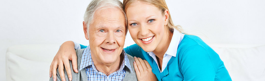 caregiver and senior man smiling