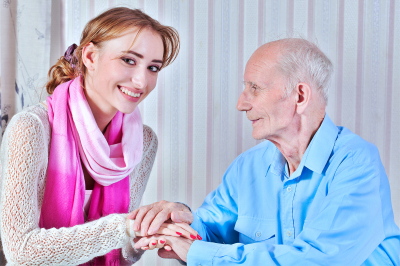 caregiver holding the hand of senior man