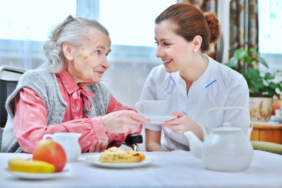 caregiver assisting senior woman in eating