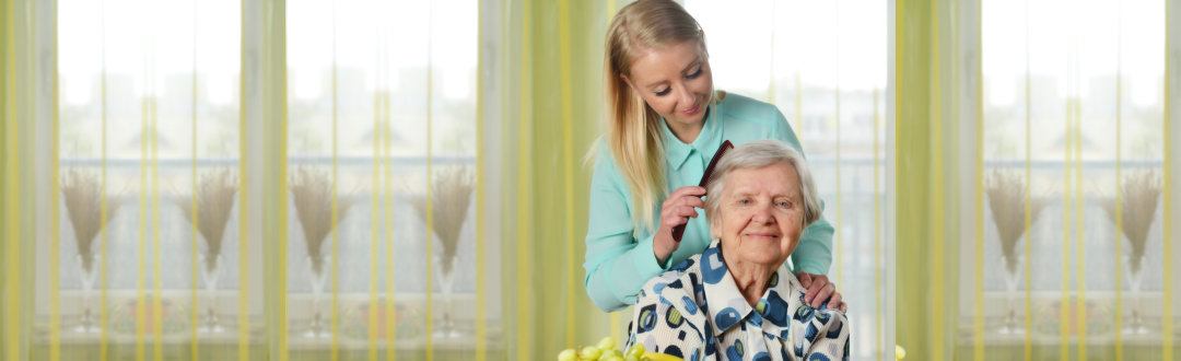 caregiver combing the hair of the senior woman