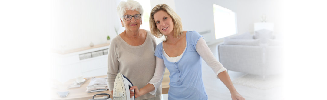 old woman with her caregiver holding an iron